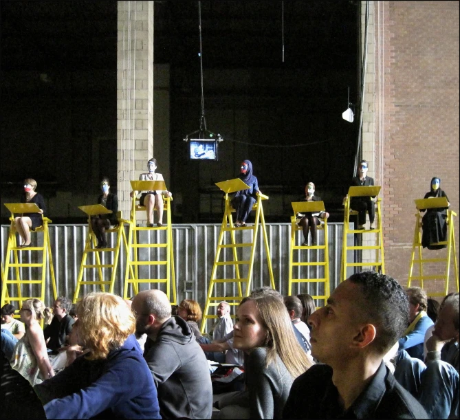 a number of people watching an event on large platforms