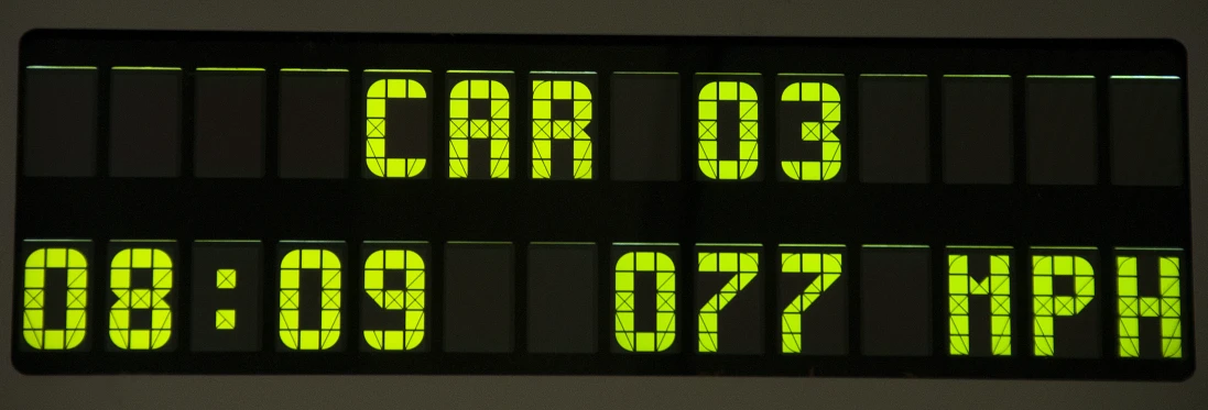 an electronic display shows the time and location for cars