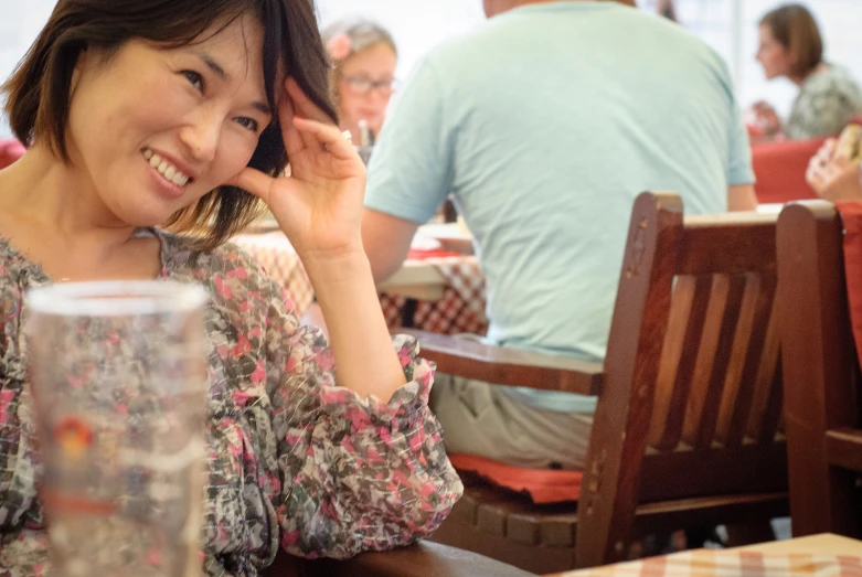 a woman sitting at a table with a glass in her hand