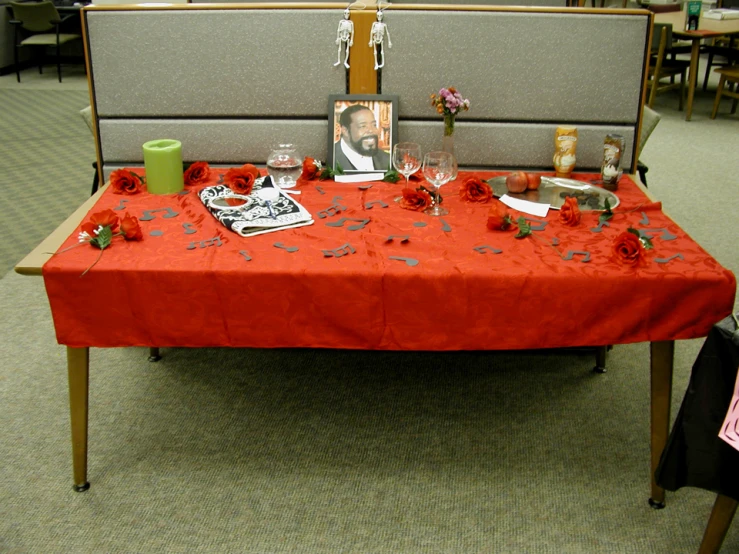 a table that has a red cloth and flowers on it