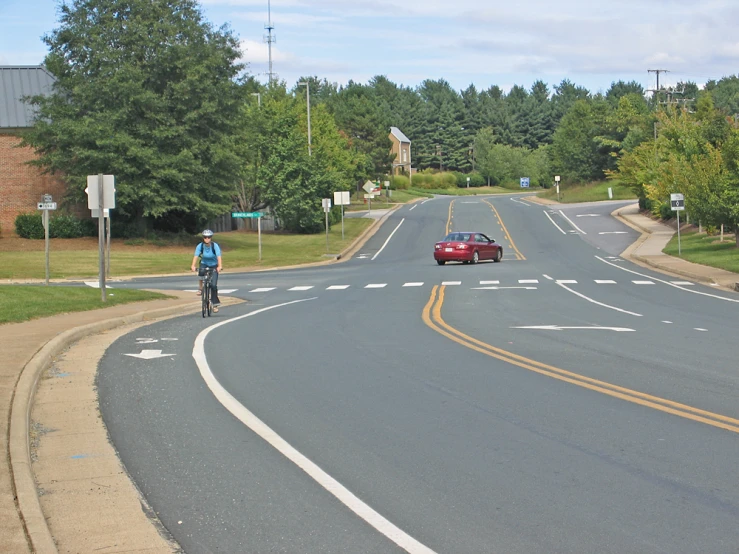 a man riding his bicycle down the road with traffic