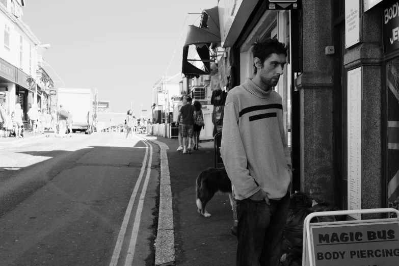 a man standing on a street with a dog in his lap