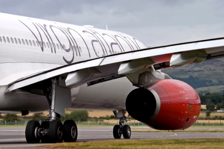 a red, white, and black plane with mountains in the background