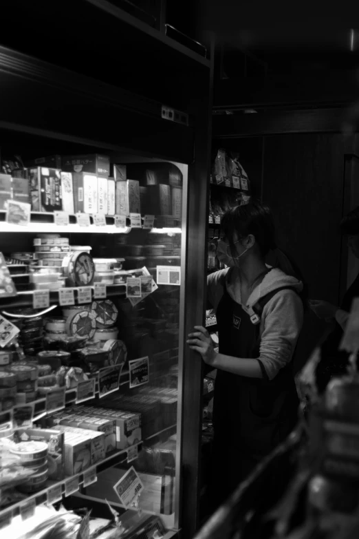 a woman standing in front of an open refrigerator