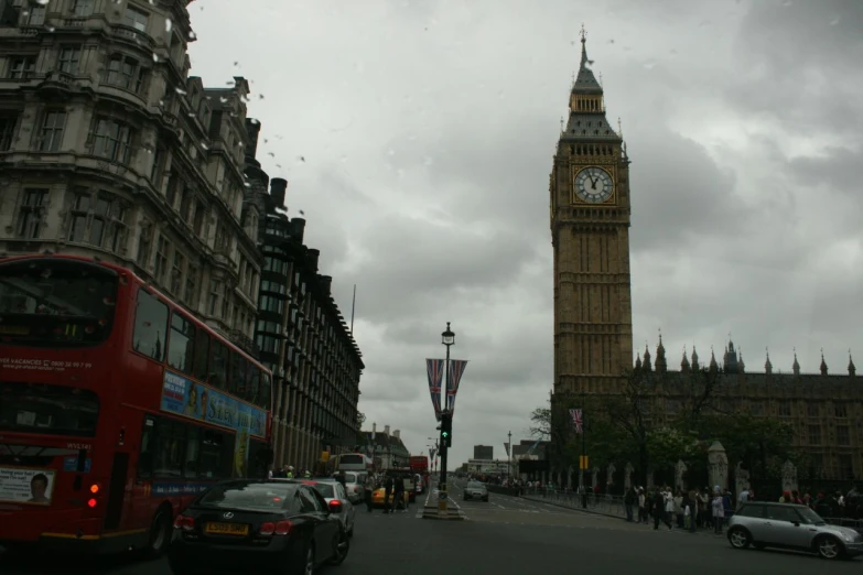 a large clock tower stands above the busy street