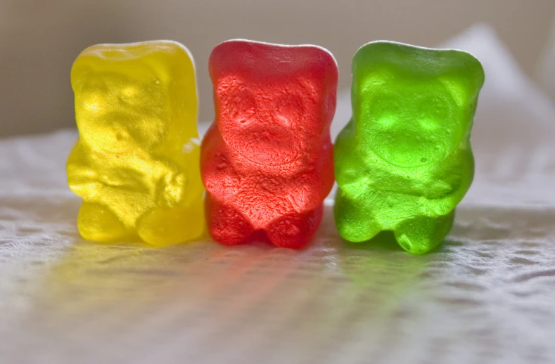 four gummy bears on the table one is white and orange