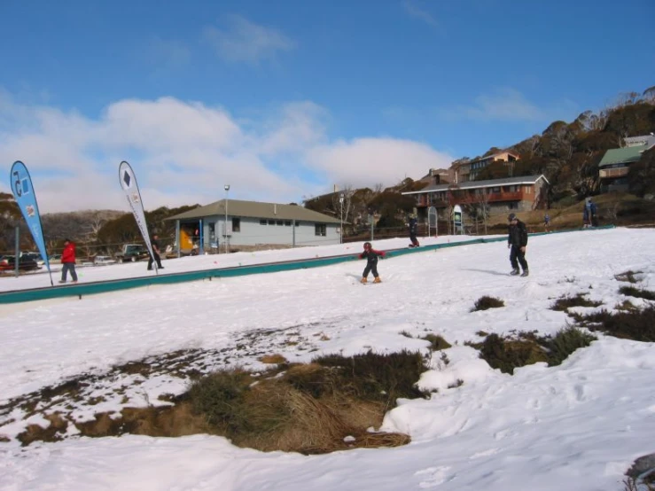 skiers in the snow on a hill with houses and mountains