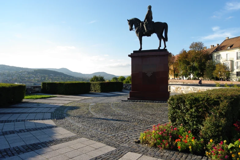 statue of a man riding on top of a horse in a park