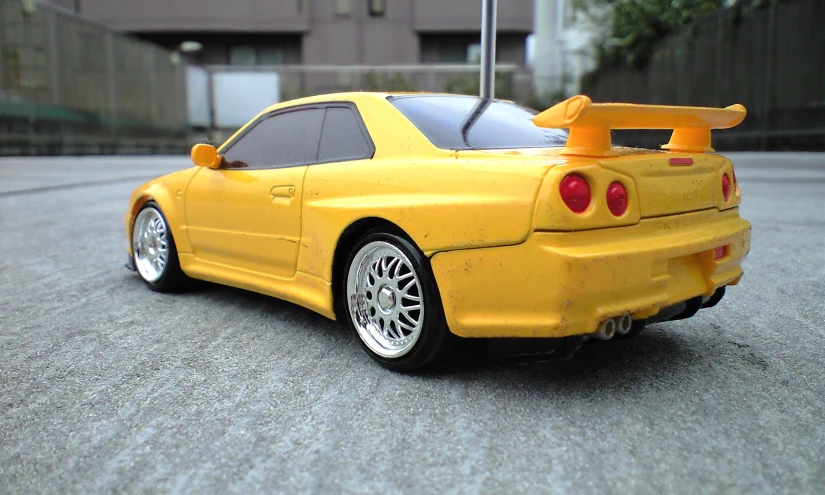 a toy car that is yellow on the street