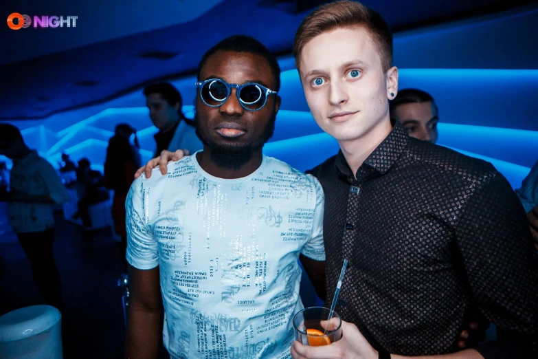 two young men are posing together at the party