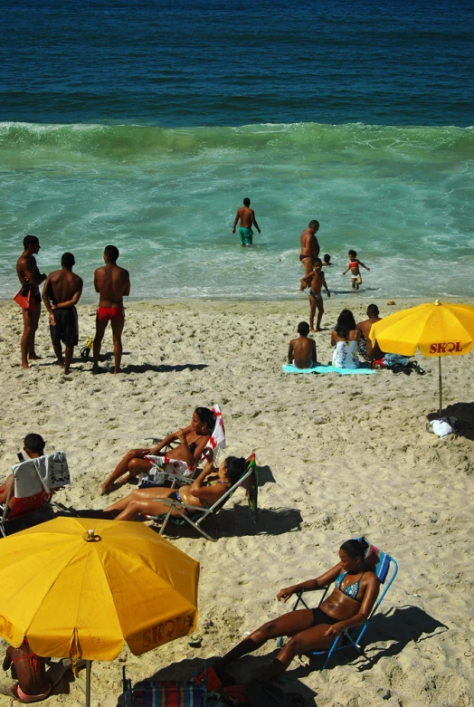 many people are on the beach near some water