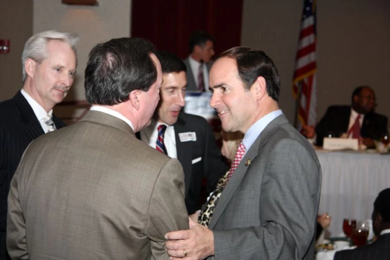 several men are smiling and standing next to each other