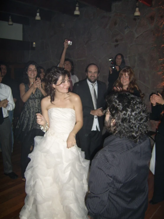 the bride in her wedding gown is dancing on the dance floor