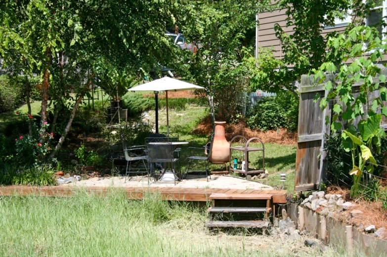 a gazebo and a table with chairs sitting under trees