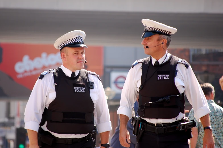 two police officers are standing in front of some people