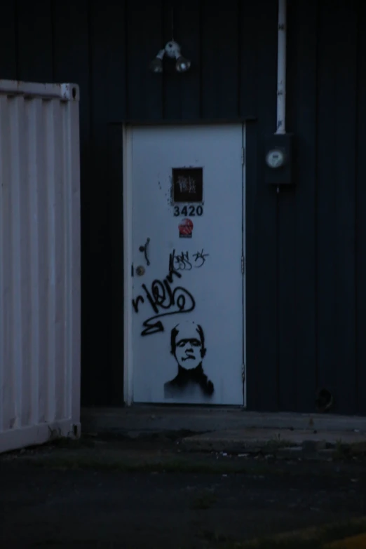 a door has graffiti on it in an empty space