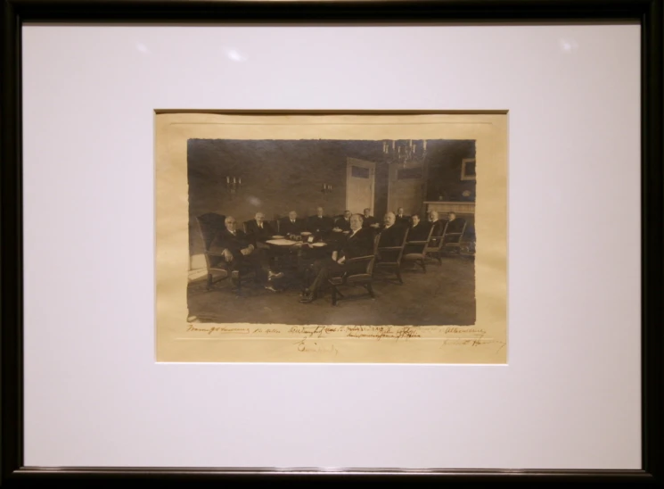antique framed po depicting men seated around a dining table