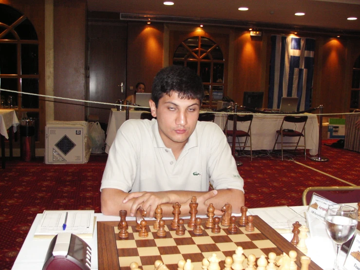a man is sitting at a chess table and playing the game