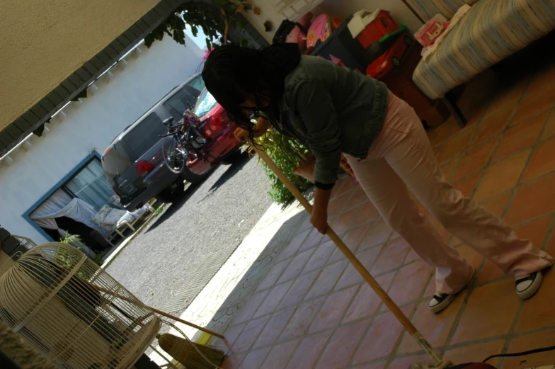 a woman cleaning a floor with a dust mop