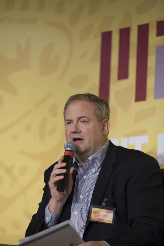 a man holding a microphone in front of a microphone with a message inside of it