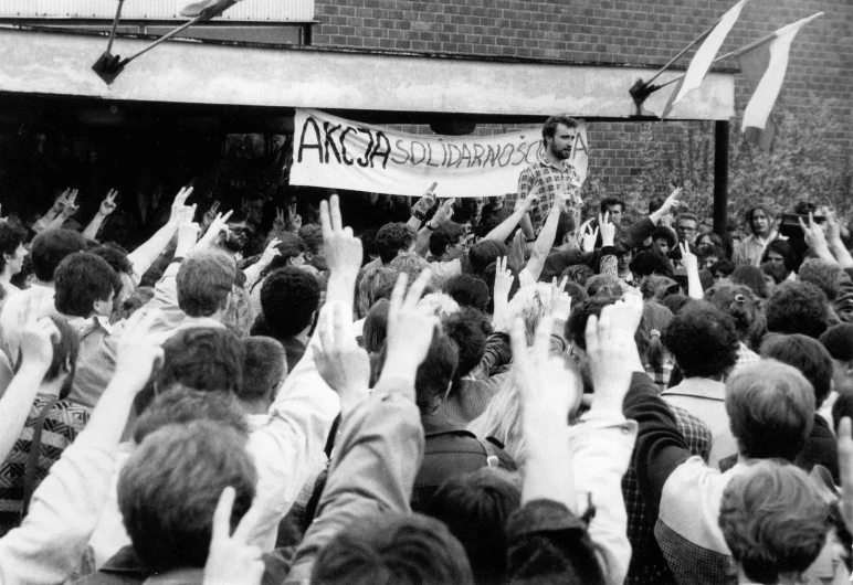 an old black and white pograph of people waving flags