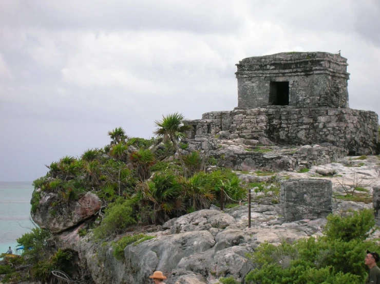an old ruins building sitting on a large rocky hill