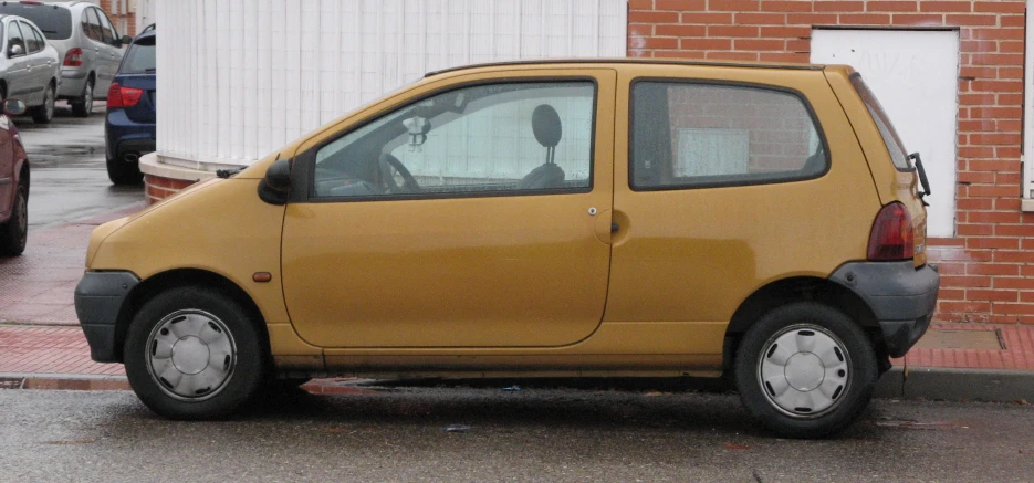 a small car sits on the street beside the sidewalk