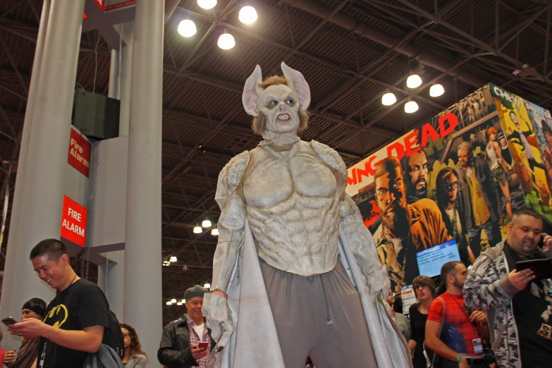 a man in a costume with white makeup and many other people