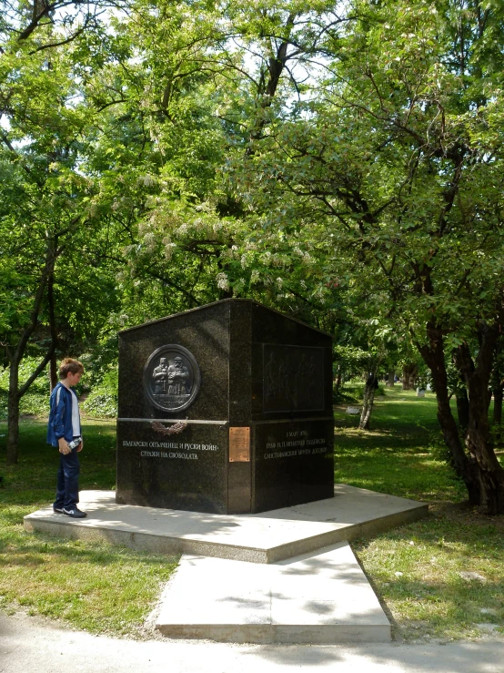 a  is standing near a monument in the park