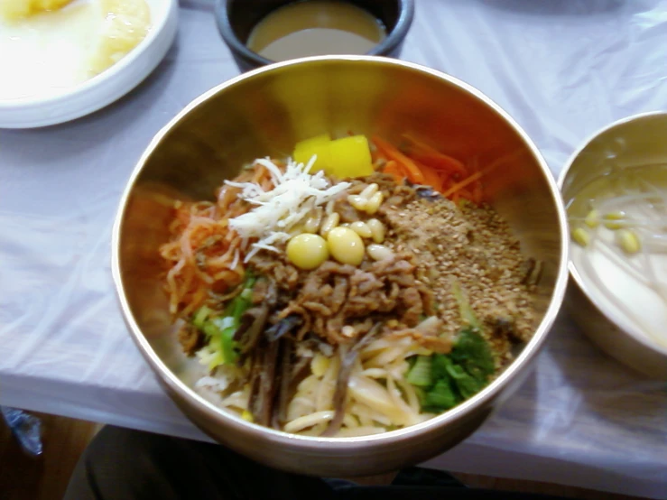 a table set with two bowls and plates of food