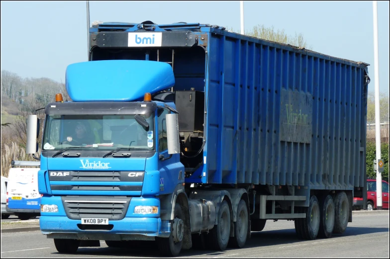 a blue semi truck driving down the street