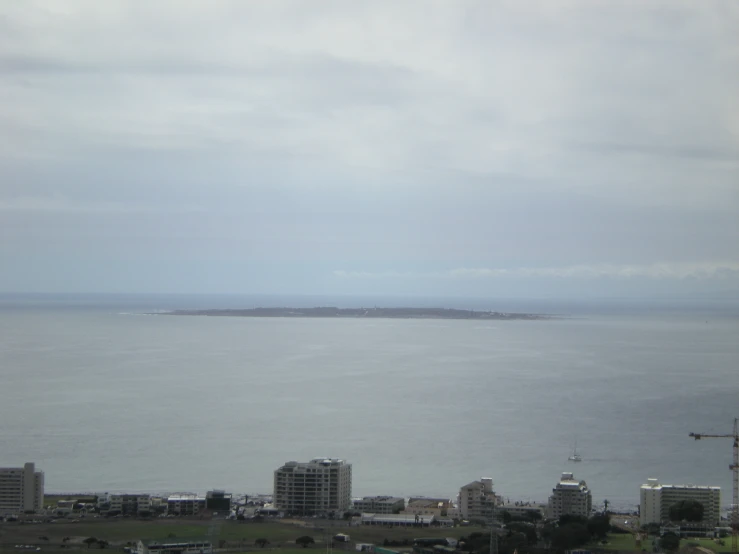 a view of an area with sea, buildings and an airplane