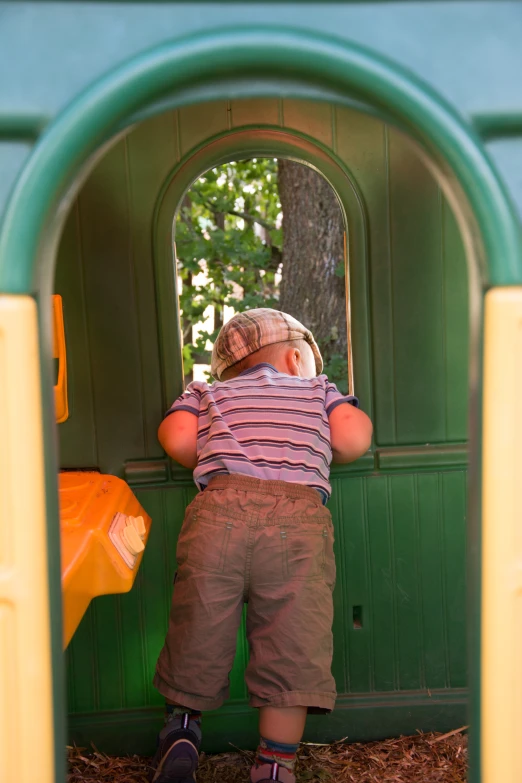 the little boy is looking through the window of a small train