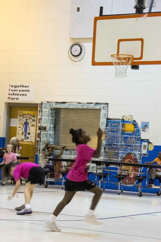 some girls playing a game of basketball on a court