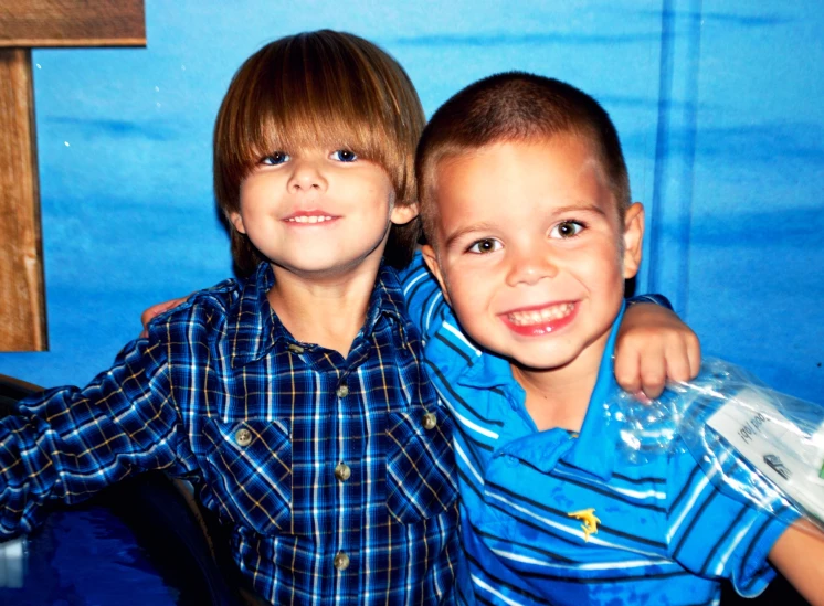 two s sitting next to each other holding bottles of water