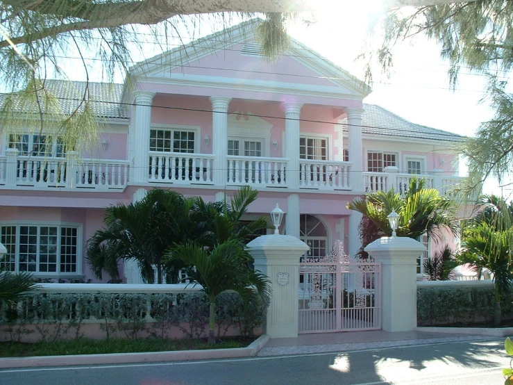 a pink house with white balconies on it