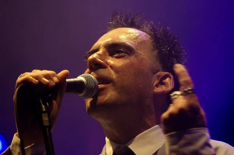 a man is singing into a microphone on stage