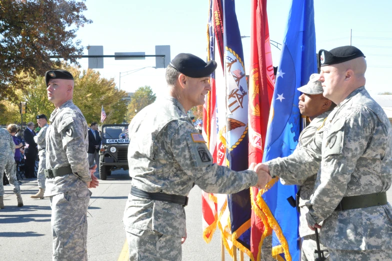 some soldiers holding onto flags and shaking hands