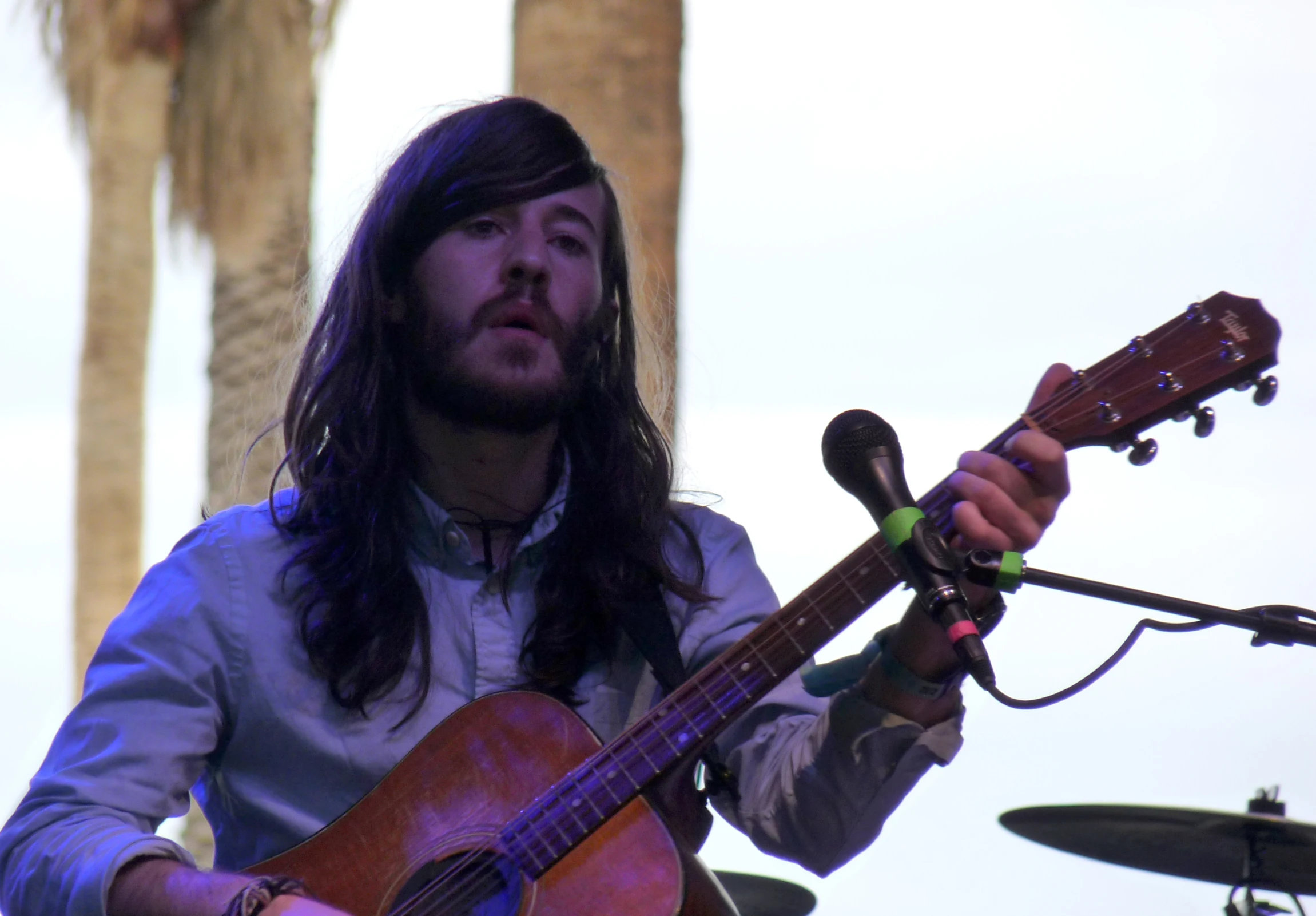 a man playing a guitar and singing at a music event