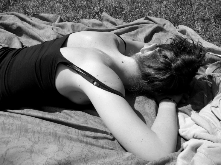 a woman laying on a blanket in the grass