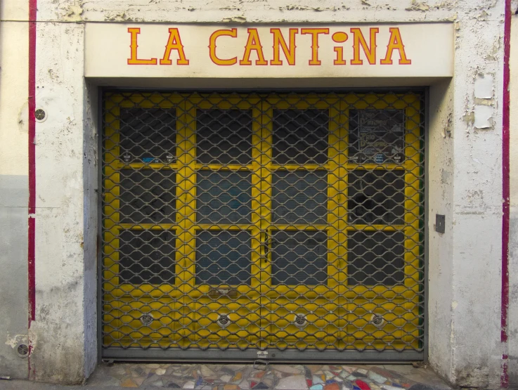 the door of an old building has yellow bars in front
