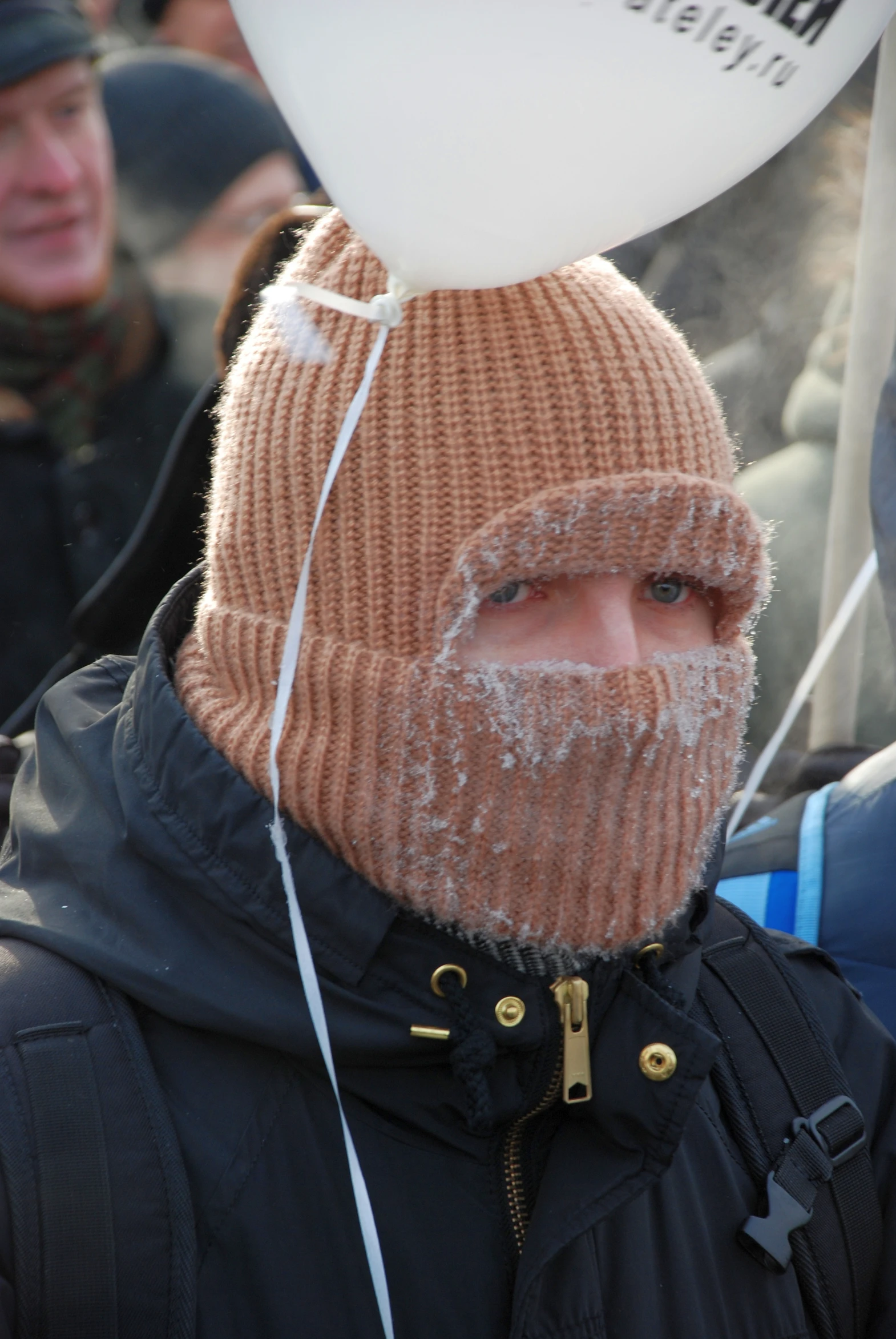 a man wearing a hat is holding a  air balloon above his head