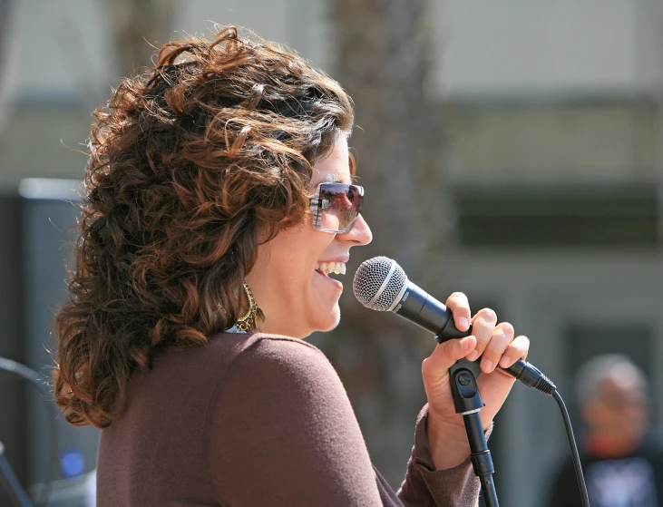 a woman with glasses on holding a microphone