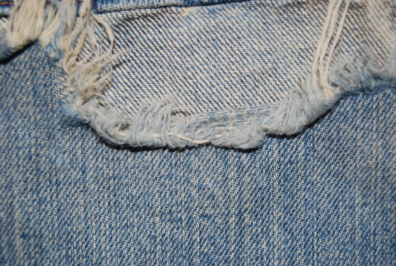 a piece of blue jean with holes and shredded fabric