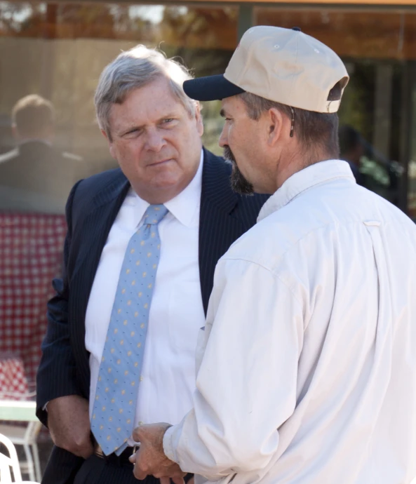 two men are talking while standing next to each other