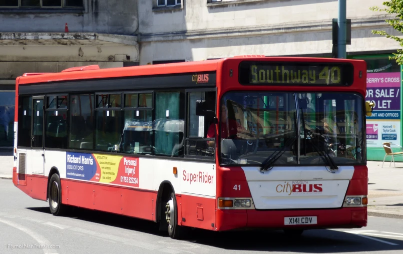 a red, white and blue city bus on street