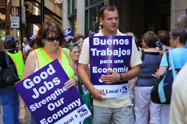 a man in a crowd holding signs that read good job