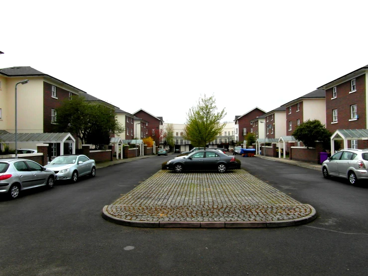 a parking lot in front of a row of brick buildings