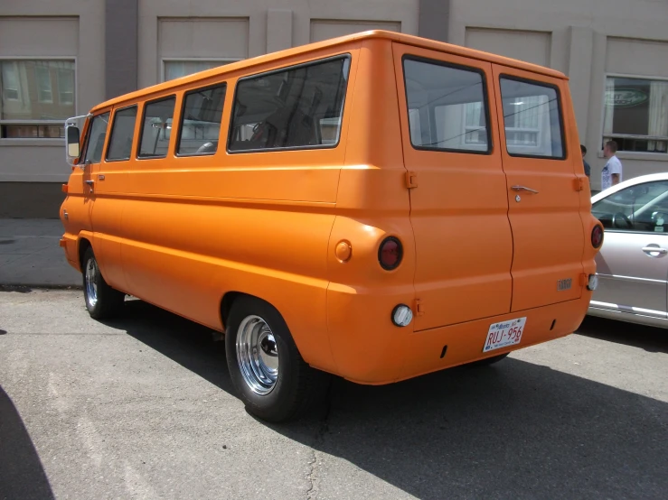 an orange car parked near another gray car