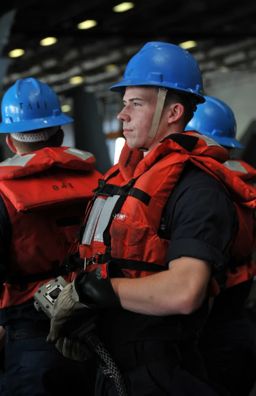 three people in red vests with helmets and goggles on